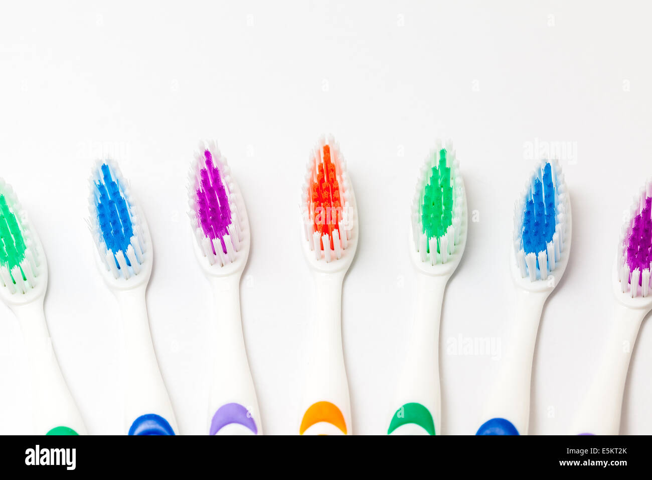 different colored plastic toothbrushes with white background Stock Photo