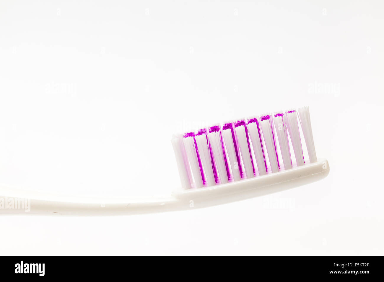 different colored plastic toothbrushes with white background Stock Photo