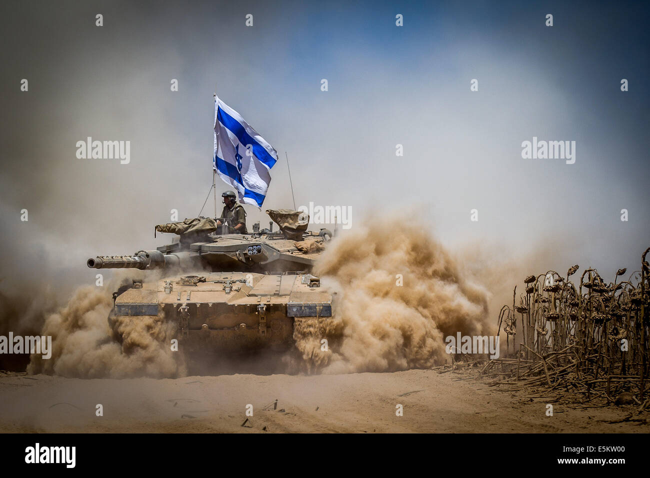 Gaza Border. 3rd Aug, 2014. An Israeli Merkava tank pulls back from the Gaza Strip to an army deployment area in southern Israel bordering the Gaza Strip, on Aug. 3, 2014. The Israeli military has announced that it will hold fire for seven hours Monday in parts of the Gaza Strip to facilitate the entry of humanitarian aid and for displaced Palestinians to return to their homes. Credit:  JINI/Xinhua/Alamy Live News Stock Photo