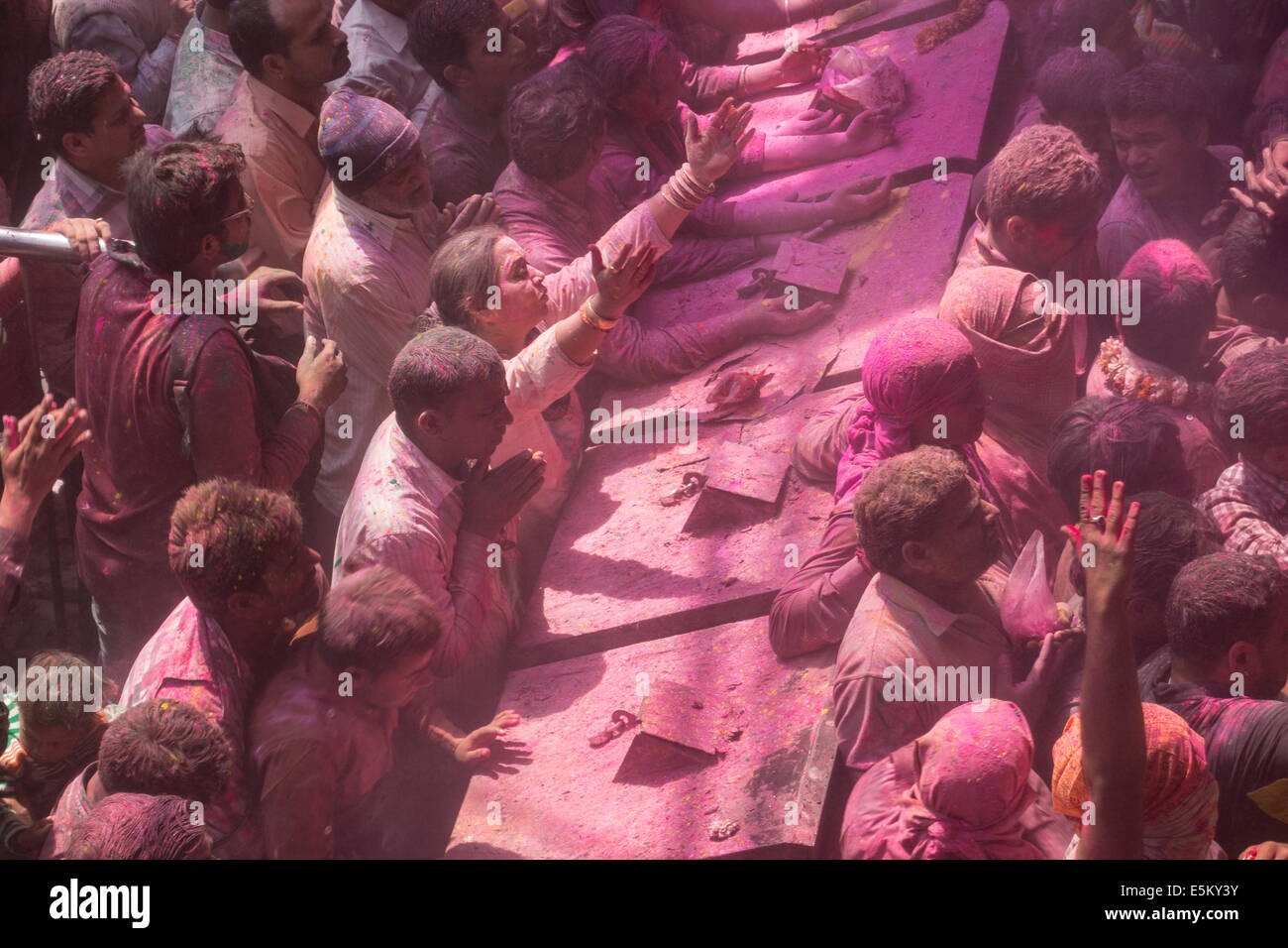 Devotees covered in coloured powder praying, Holi festival, Banke Bihari Temple, Vrindavan, Uttar Pradesh, India Stock Photo
