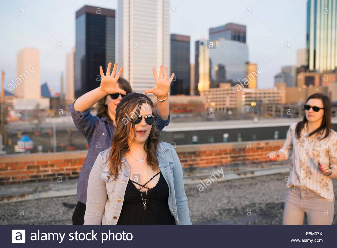 Playful friends on urban rooftop Stock Photo - Alamy