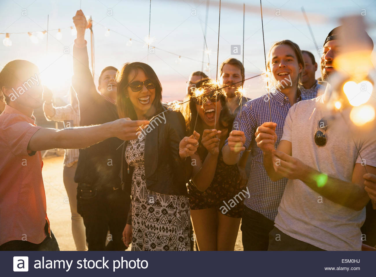 Friends with sparklers enjoying party Stock Photo