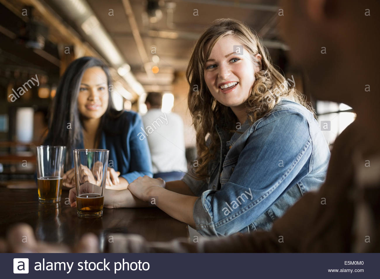 Friends drinking beer at pub Stock Photo