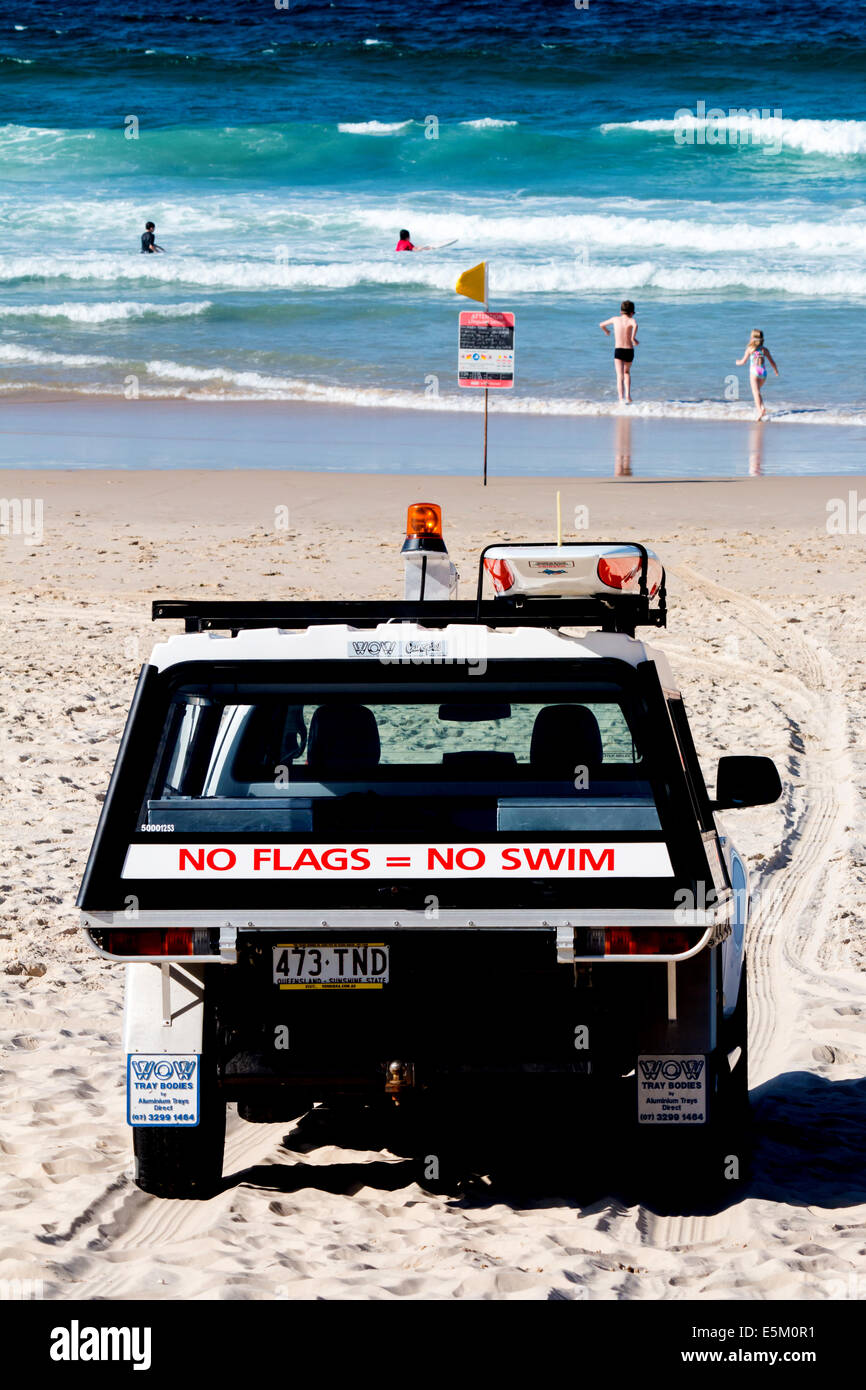 Life savers in vehicle parked on the beach keeping watch on those enjoying the water on the Gold Coast in Queensland Australia Stock Photo