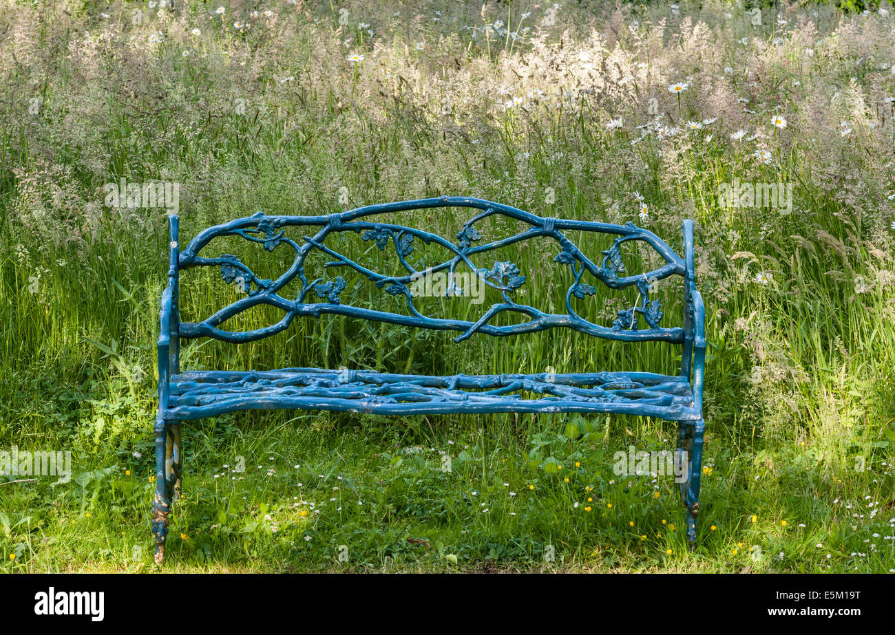 Hidcote Manor Garden, Gloucestershire, UK, made by Lawrence Johnston in the early 20c. A wrought iron bench in the meadow Stock Photo