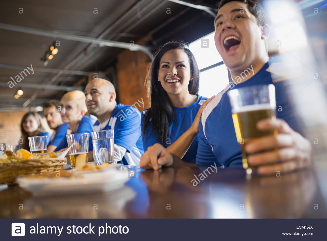 Sports fans watching TV at bar in pub Stock Photo Alamy