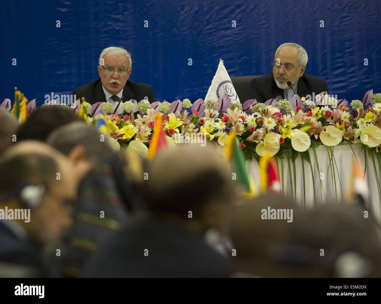 Tehran, Iran. 4th Aug, 2014. August 4, 2014 - Tehran, Iran - Iran's Foreign Minister MOHAMMAD JAVAD ZARIF (R) looks on as Palestinian Minister of Foreign Affairs RIAD AL-MALKI addresses the opening of Non-Aligned Movement Ministerial Committee on Palestine Meeting on Situation in Gaza, in Tehran. Morteza Nikoubazl/ZUMAPRESS Credit:  Morteza Nikoubazl/ZUMA Wire/Alamy Live News Stock Photo