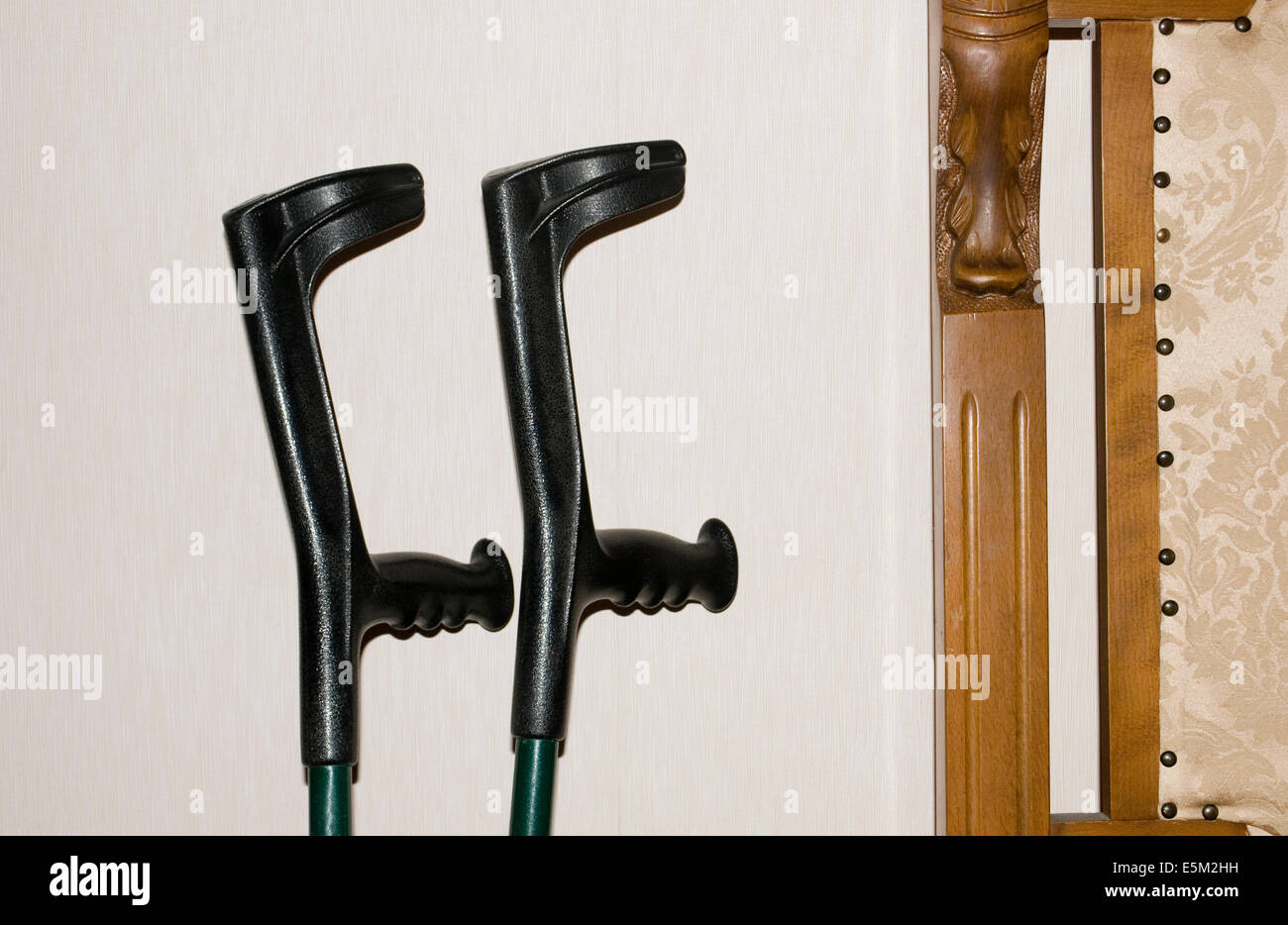 Pair of Crutches Leaning on Wall Stock Photo