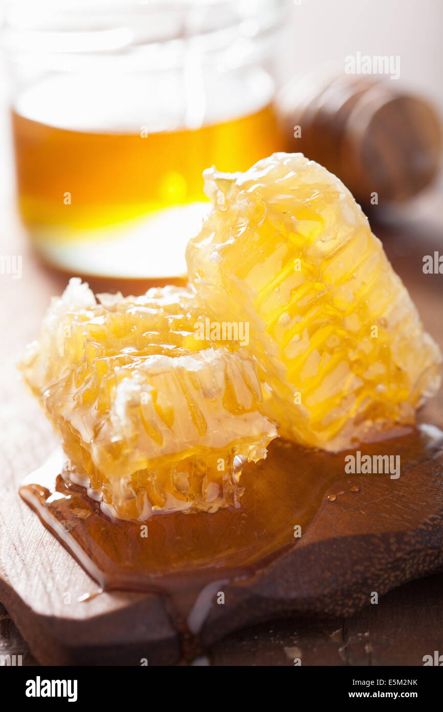honeycomb dipper and honey in jar on wooden background Stock Photo