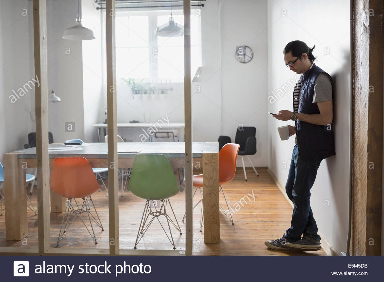 Businessman using cell phone in conference room Stock Photo