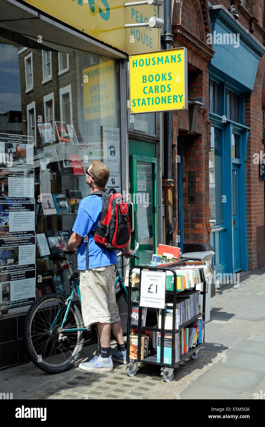 Man with bike outside Housmans bookshop, Caledonian Road, London Borough of Islington England Britain UK Stock Photo