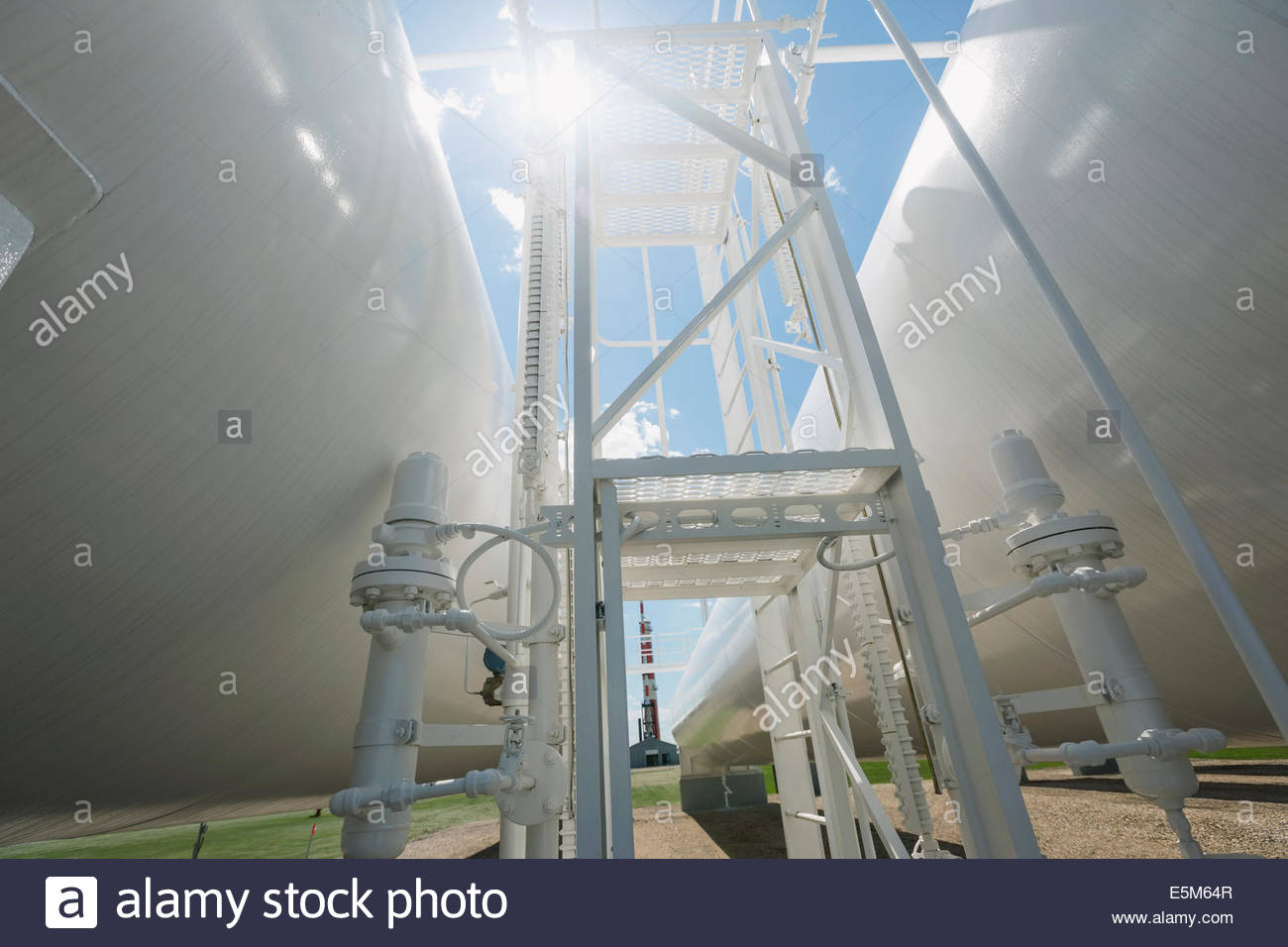 Sun shining over natural gas tanks Stock Photo Alamy