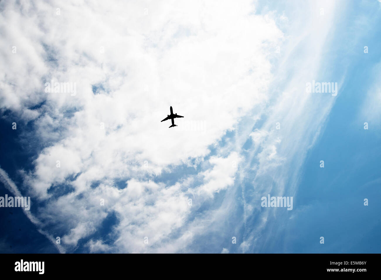 Plane silhouetted against clouds over London Stock Photo