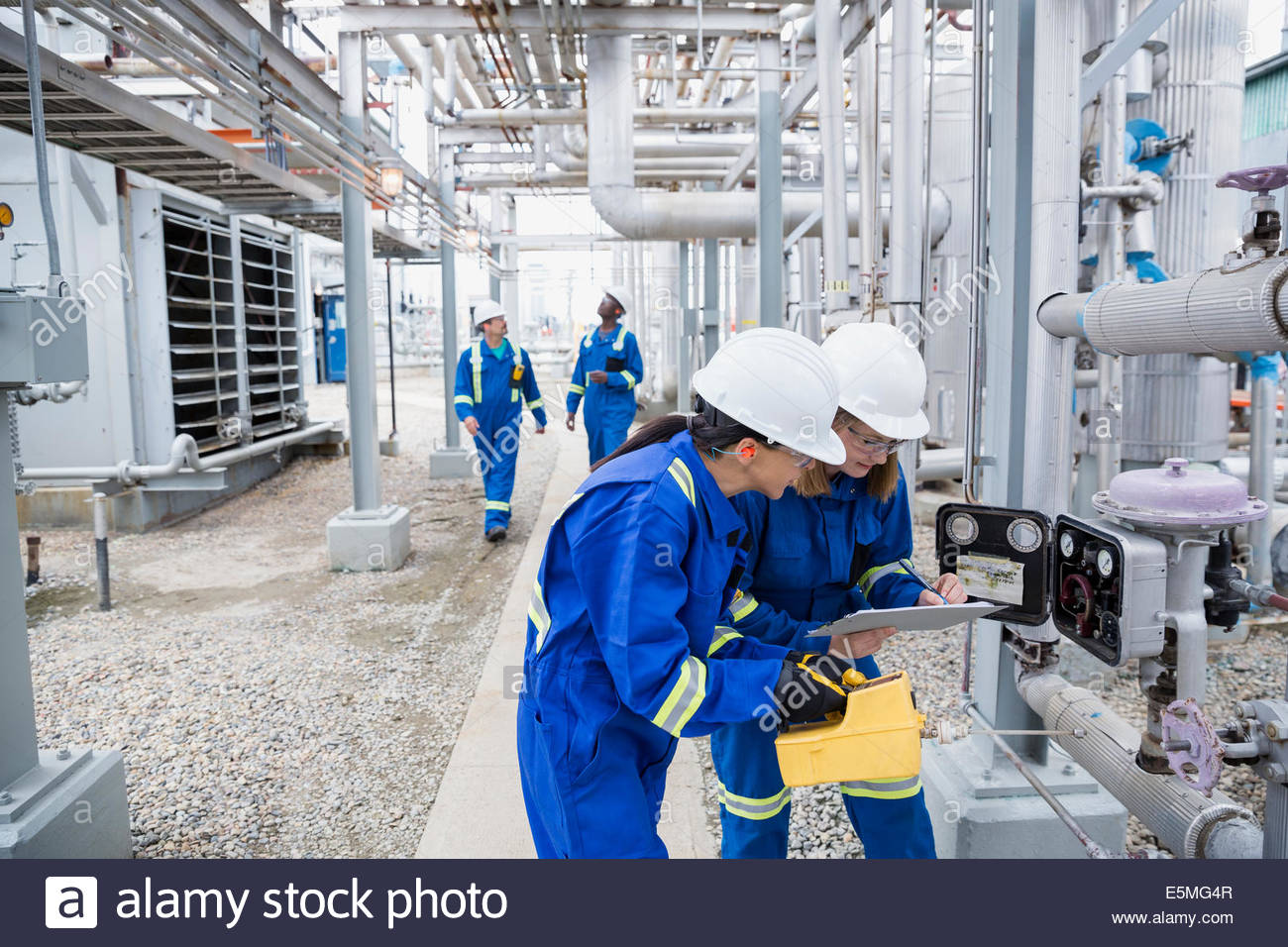 Workers checking gauges at gas plant Stock Photo Alamy