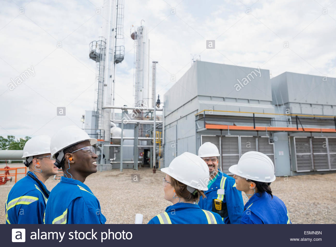 Workers meeting outside gas plant Stock Photo