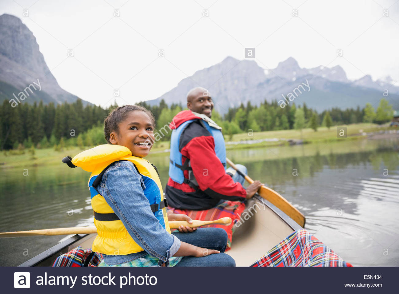 Father and daughter canoeing in lake Stock Photo