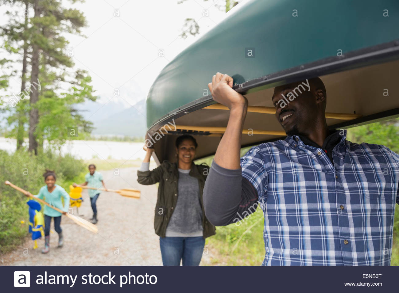 Family carrying canoe and oars Stock Photo Alamy