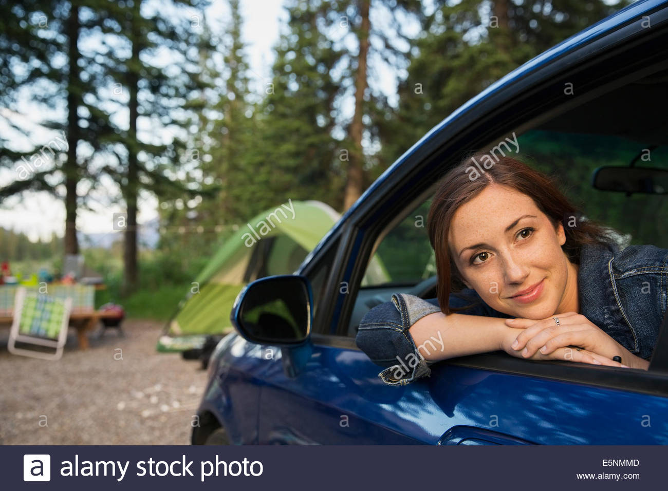 Smiling woman in car at campsite Stock Photo