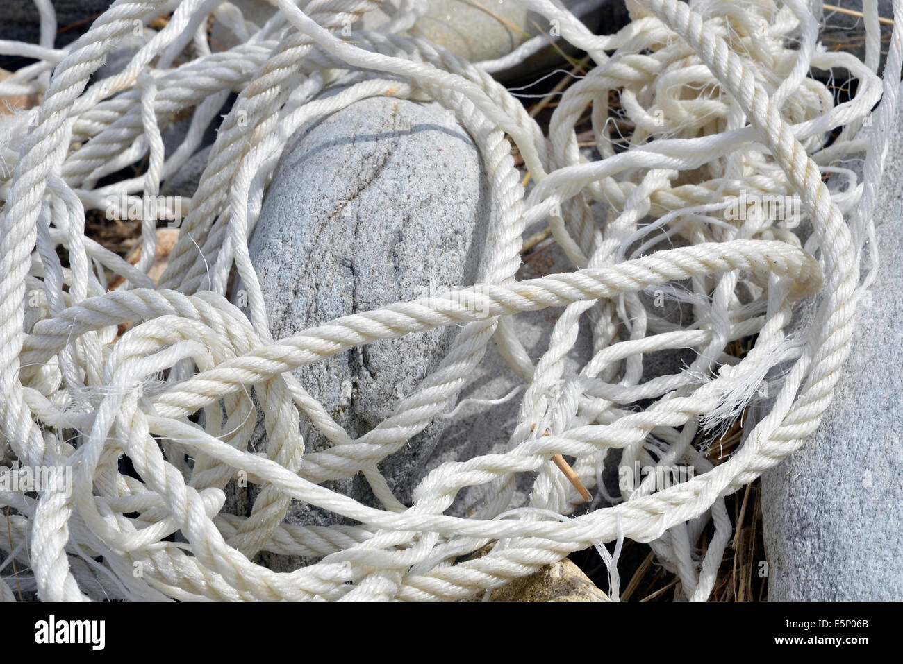 Old rope washed onto the seashore and tangled up amongst rounded