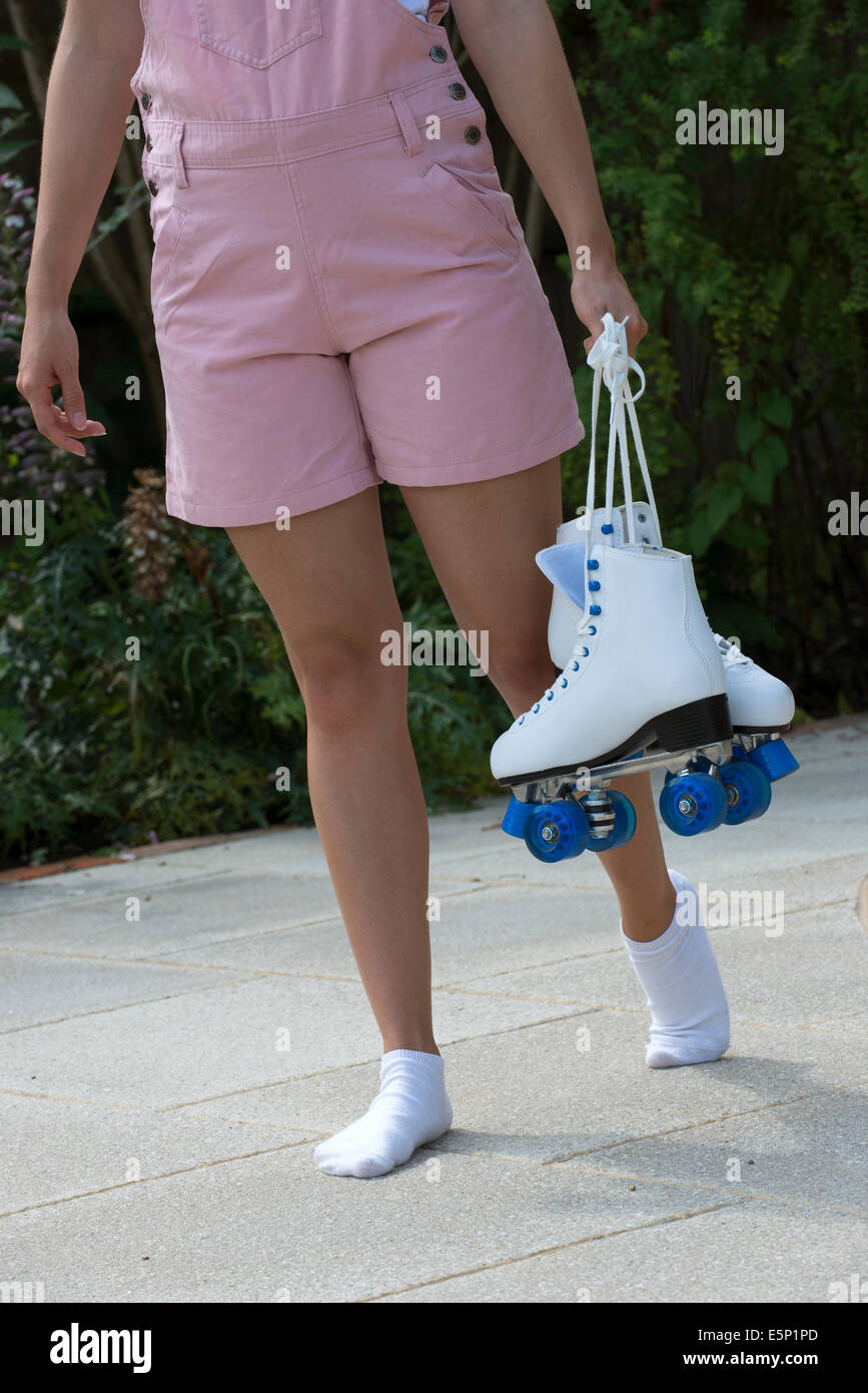 Teenage roller skater carrying her quad skates Stock Photo Alamy