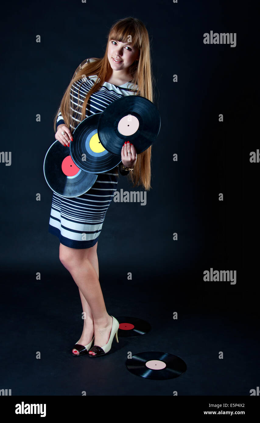 Beautiful caucasian girl with long blond hair wearing striped dress with vinyl discs Stock Photo