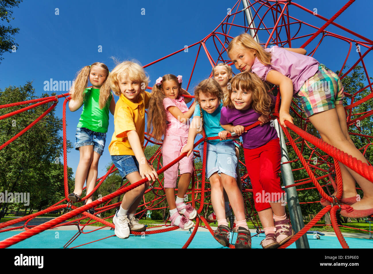 Kids standing in a row on red ropes of playground Stock Photo - Alamy