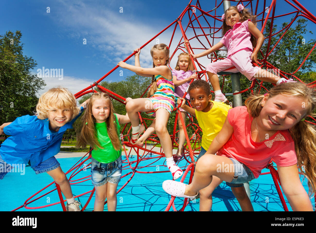 Happy group of kids on red ropes together in park Stock Photo