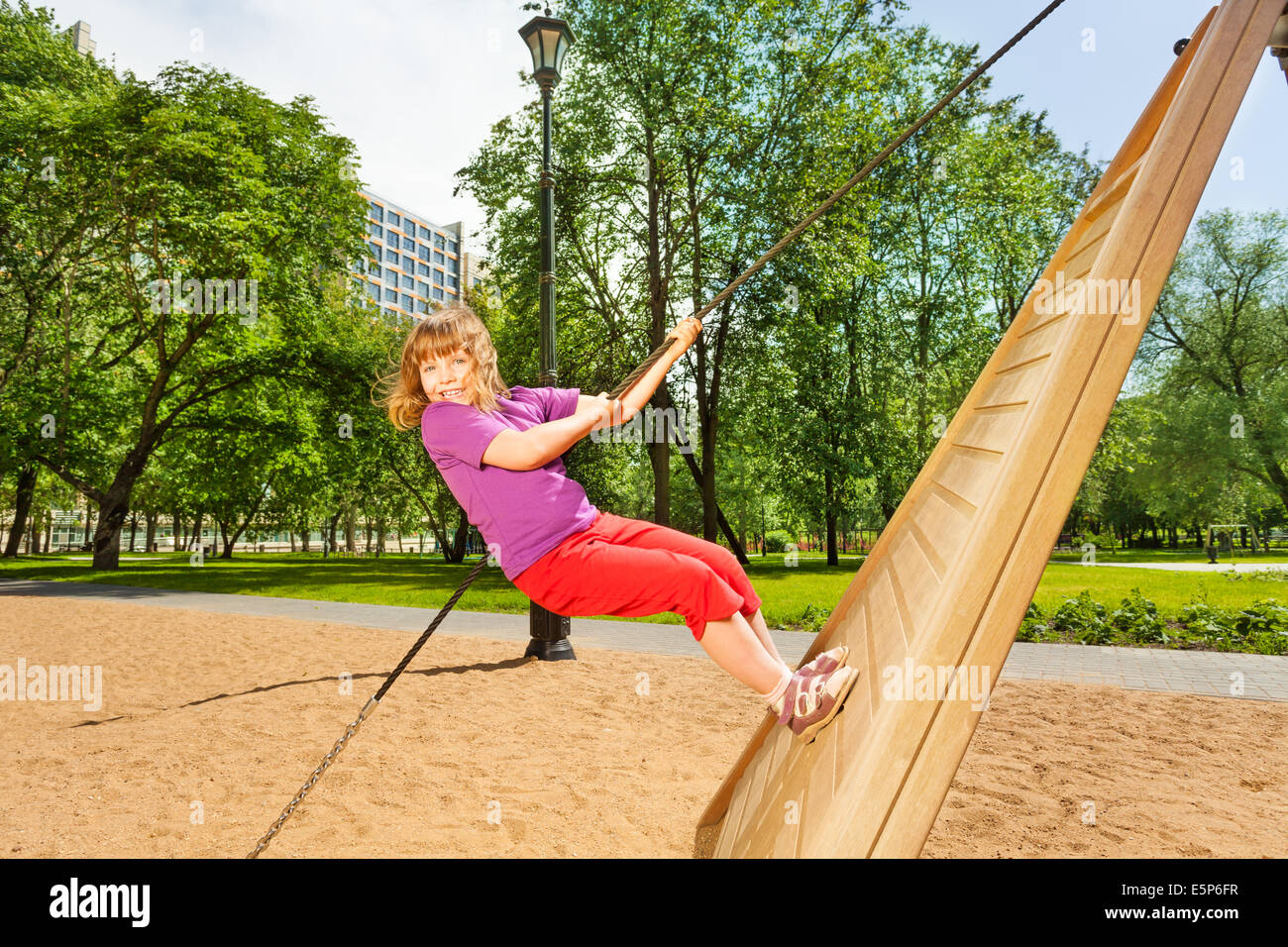 Girl climbing on wooden construction in the park Stock Photo