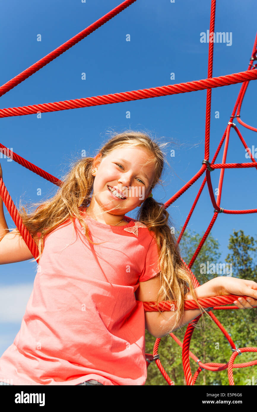 Girl On High Ropes Portrait of blond smiling girl on net ropes Stock Photo - Alamy