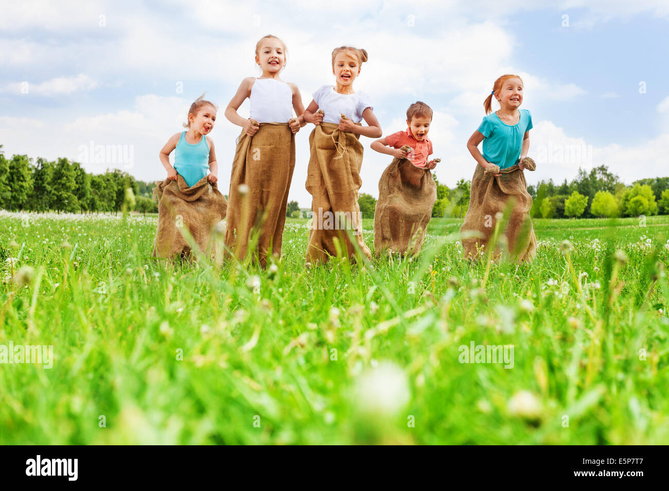 Group of five happy children jumping outdoors., Group of fi…