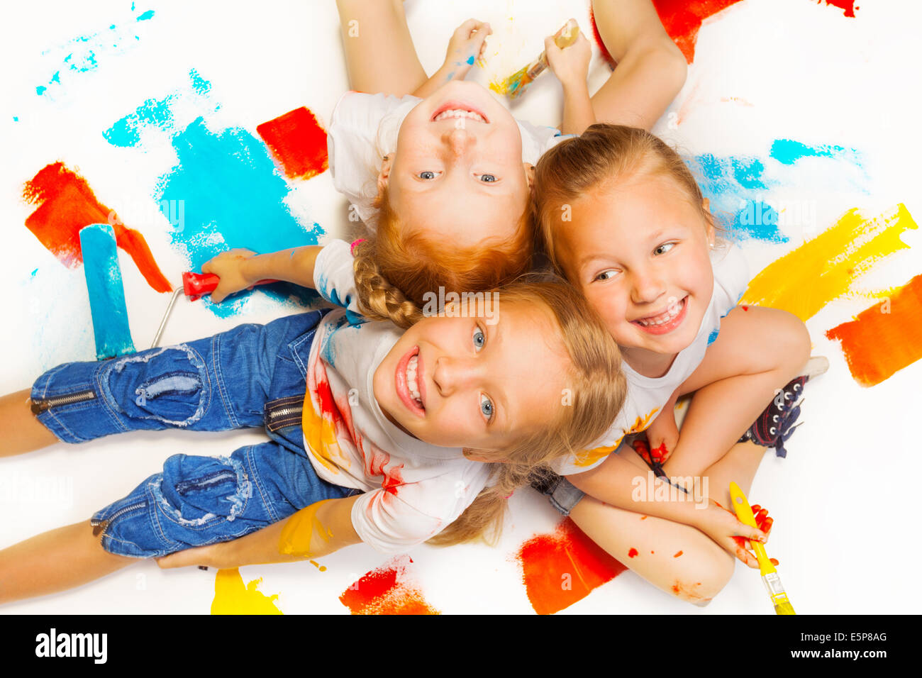 Three funny girls sitting on a floor Stock Photo - Alamy