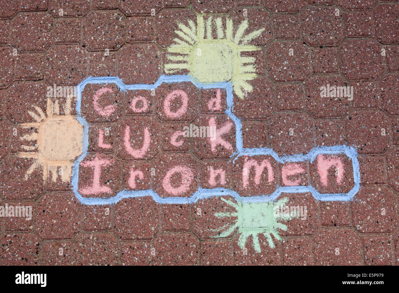Chalk writing in a sidewalk to wish triathletes good luck at the 2014 Lake Placid Ironman Triathlon. Stock Photo