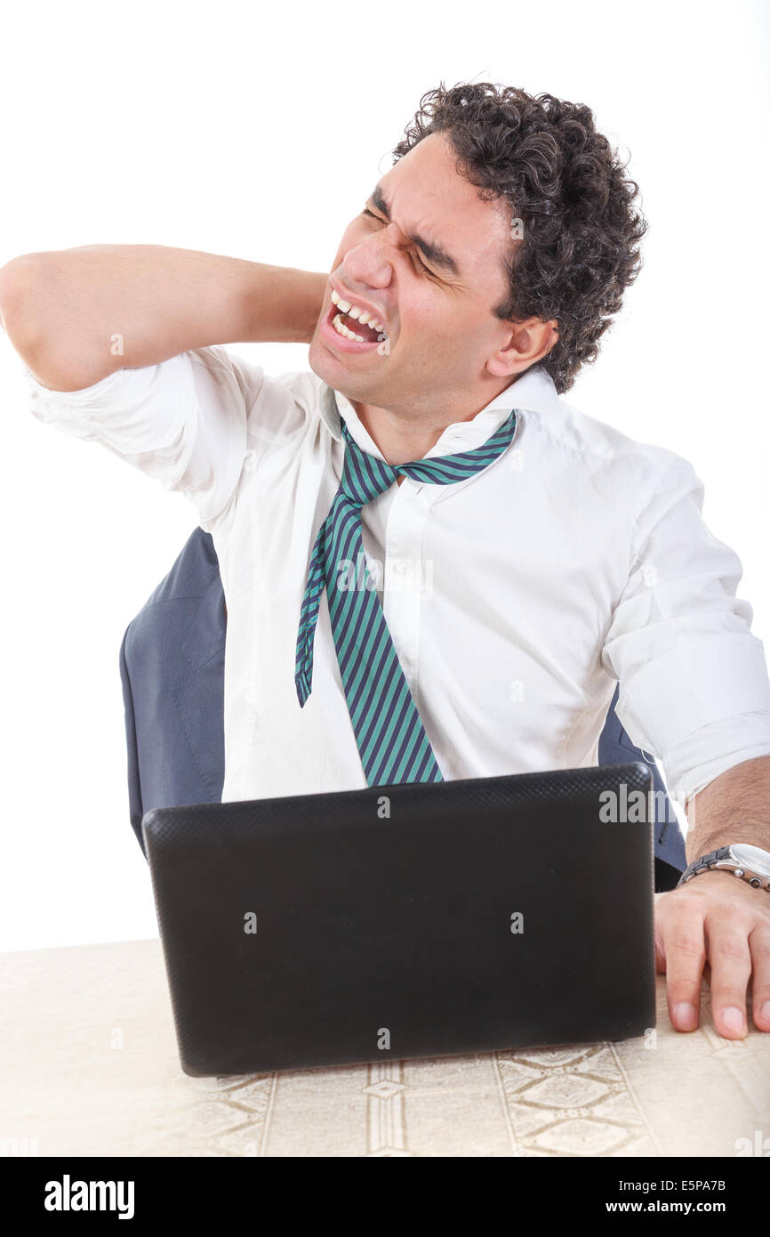 Photo of an desperate caucasian business man frustrated with work sitting in front of a laptop with his hand on neck. Stiffness, Stock Photo