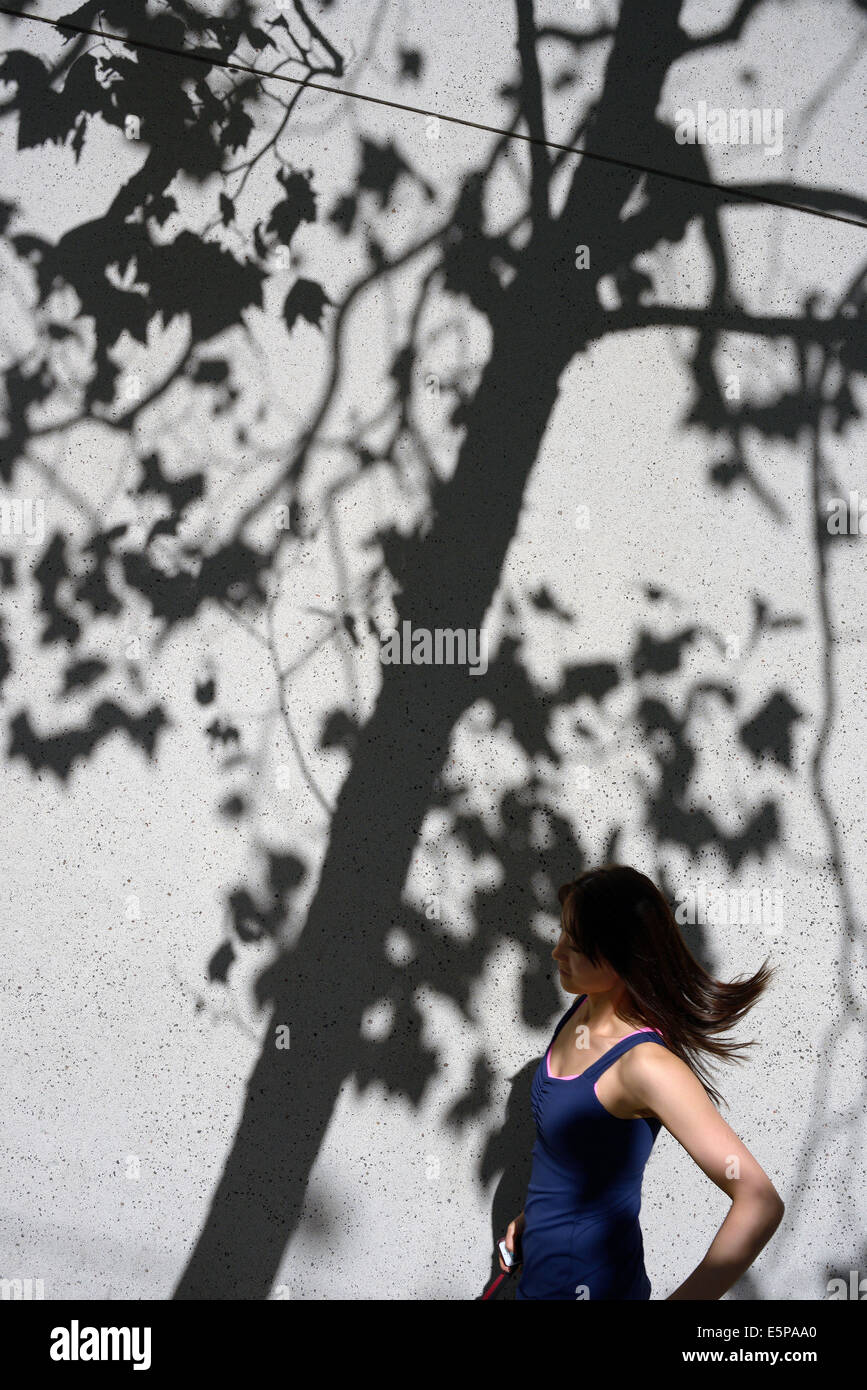 woman runs tree shadow san francisco Stock Photo