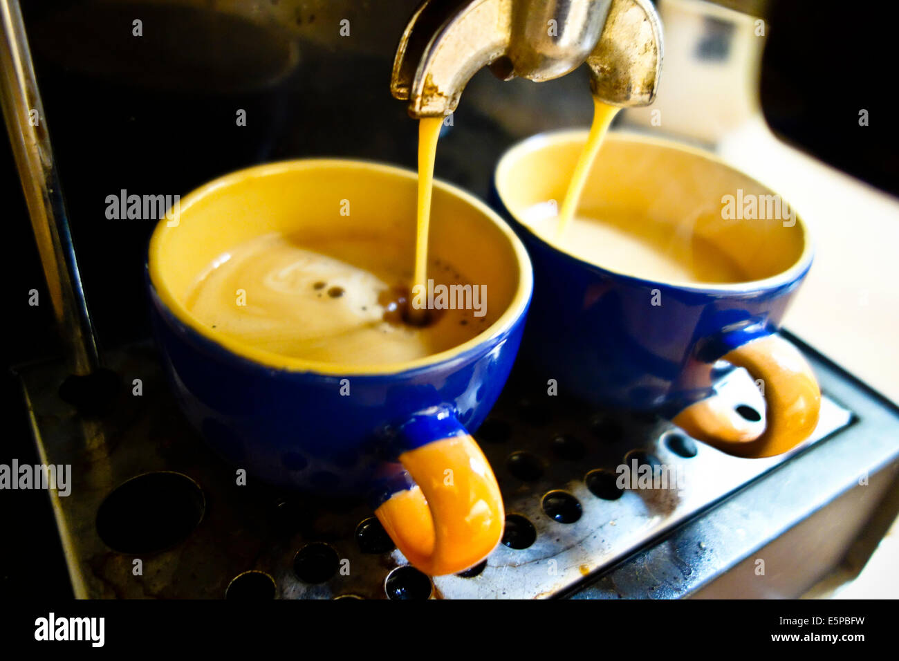 Espresso coffee into cups poured from machine Stock Photo Alamy