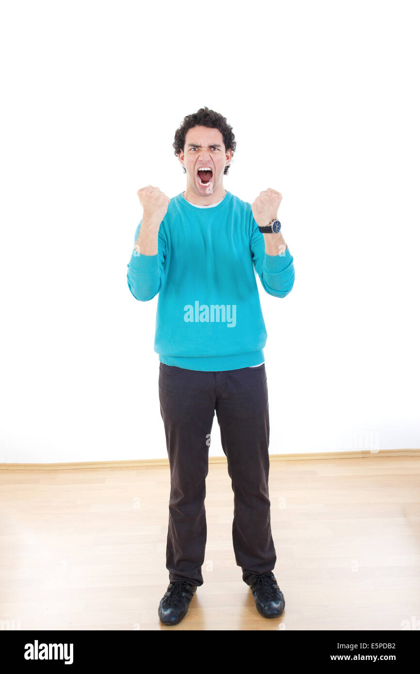 Young man screaming standing with clenched fists with expression Stock
