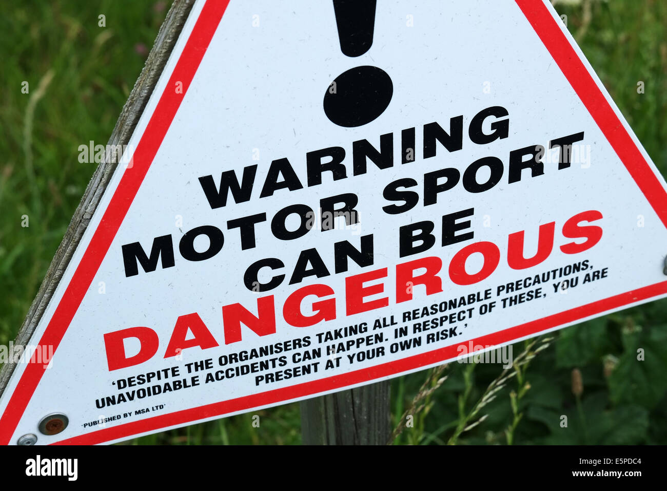 Motor sport is dangerous warning sign at race track. Stock Photo