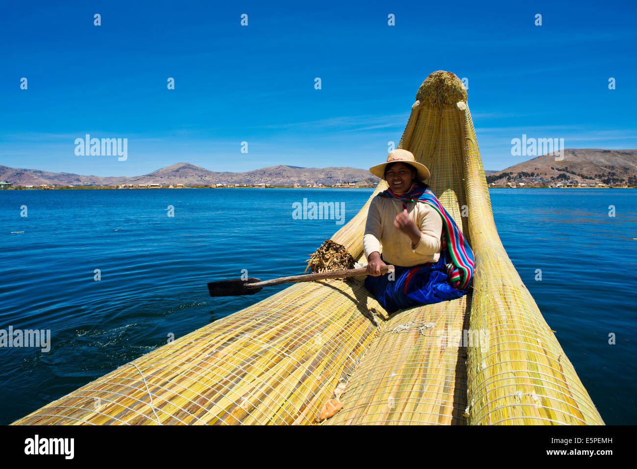 Local in a traditional rowing boat of Totora reed on Lake Titicaca, Peru Stock Photo