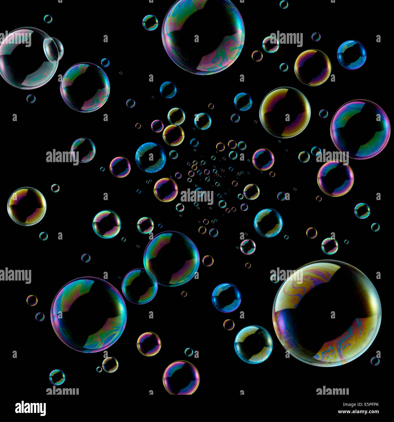 soap bubbles coming out from middle against black background Stock
