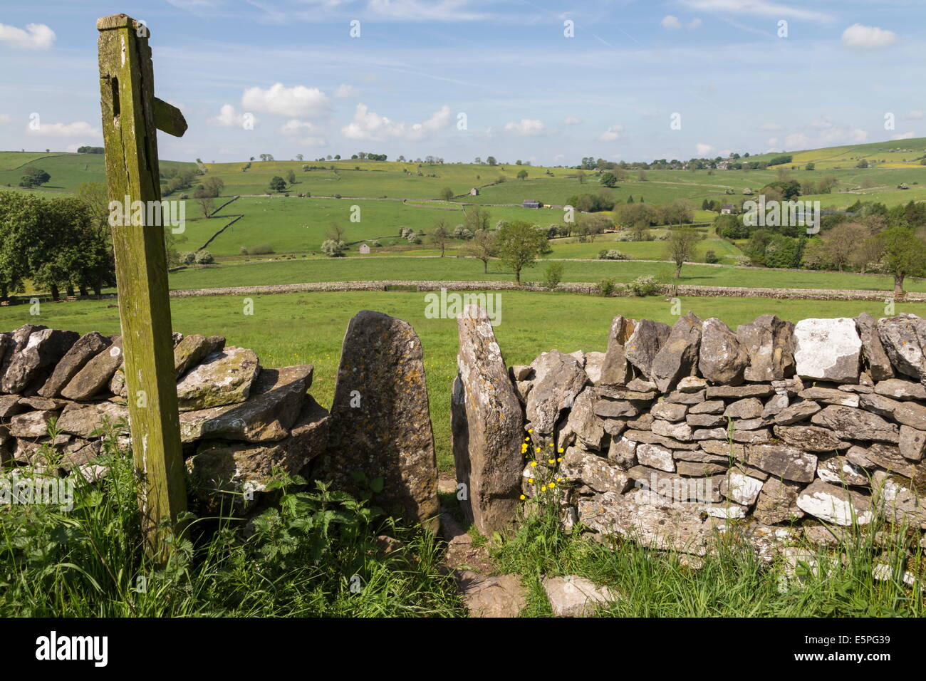 Footpath sign and stone stile with dry stone wall, near Alstonefield, Peak District National Park, Staffordshire, England, UK Stock Photo