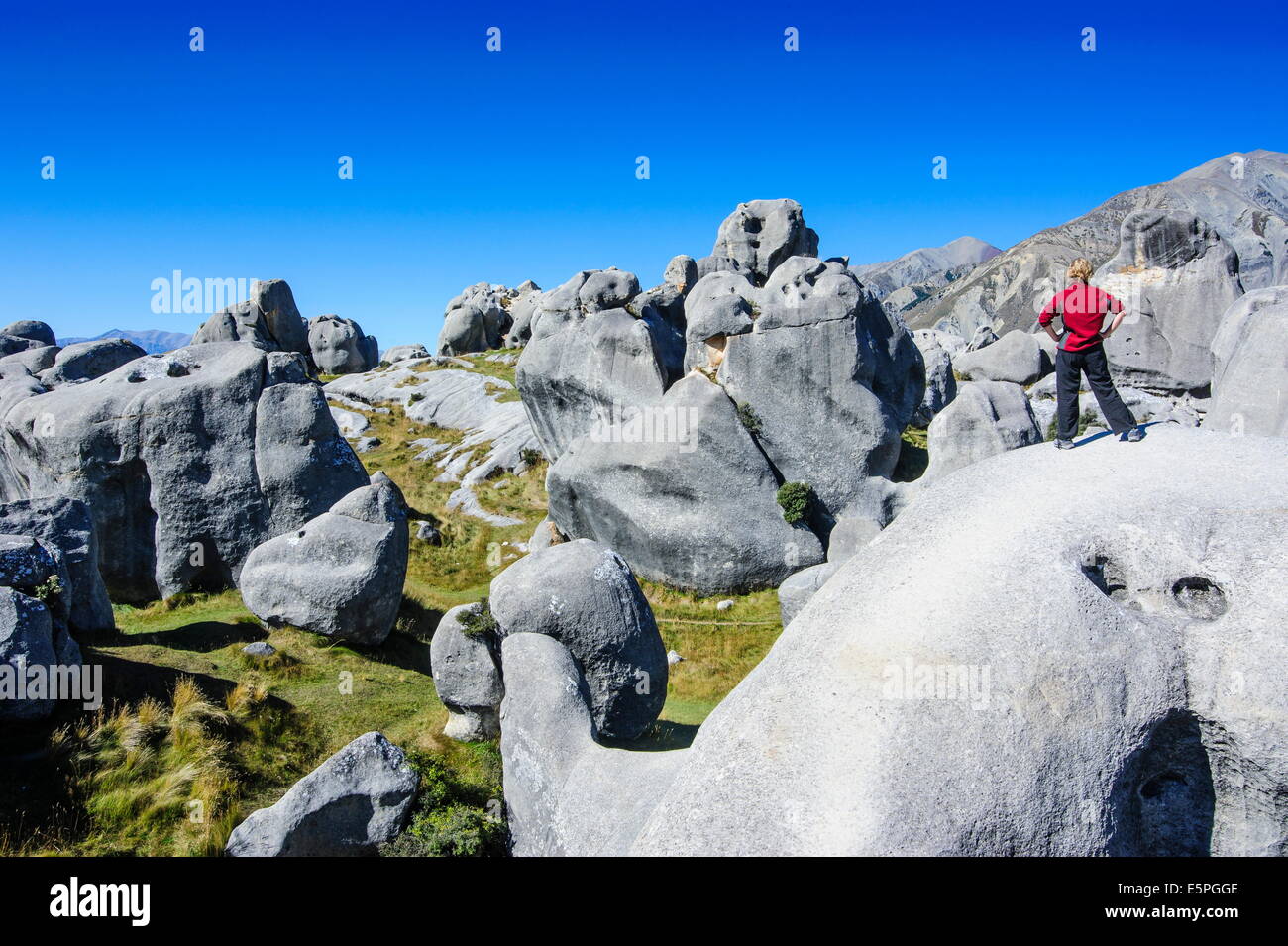 Woman standing on the limestone outcrops of Castle Hill, Canterbury, South Island, New Zealand, Pacific Stock Photo