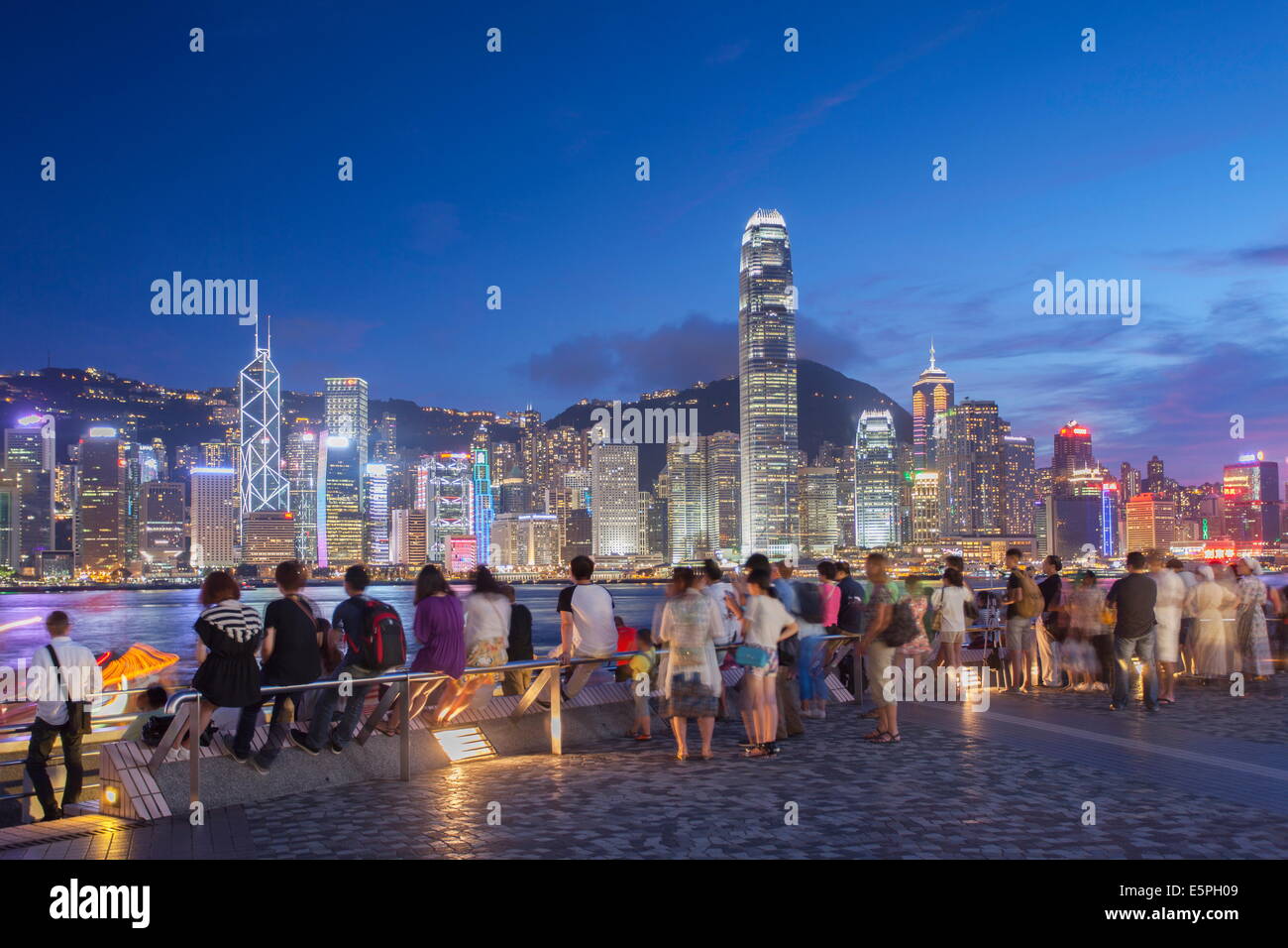 Tourists looking at Hong Kong Island skyline from Tsim Sha Tsui at dusk, Hong Kong, China, Asia Stock Photo