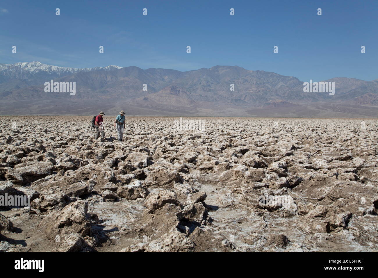 Tourists inspecting the large halite salt crystal formations, Devils Golf Course, Death Valley National Park, California, USA Stock Photo