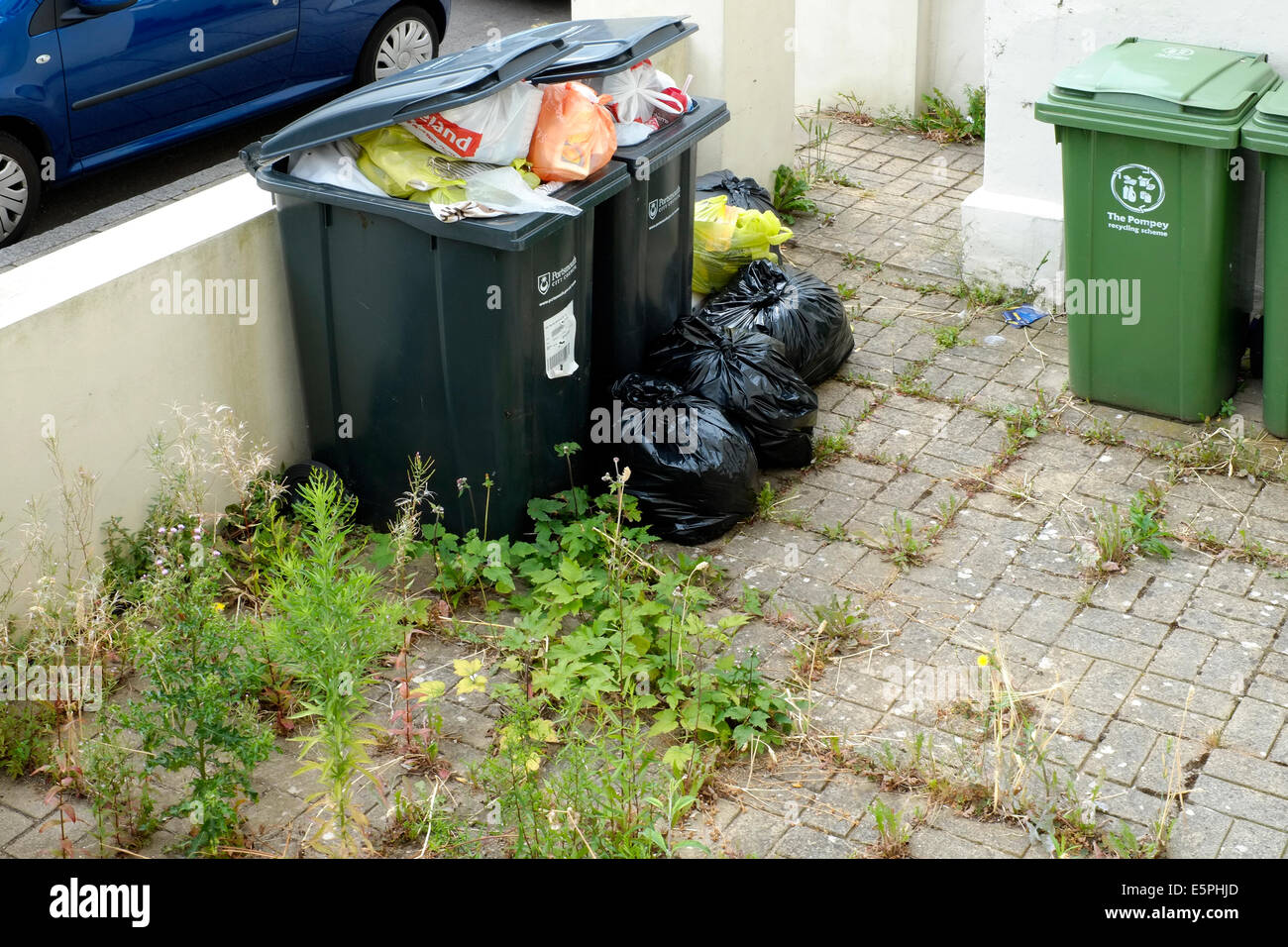 domestic wheelie bins overflowing with rubbish awaiting collection and emptying england uk Stock Photo