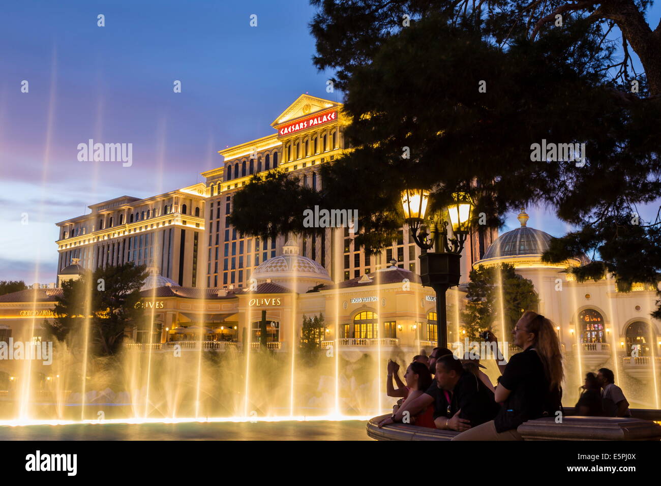 Watching the Bellagio Fountains at dusk, The Strip, Las Vegas, Nevada, United States of America, North America Stock Photo