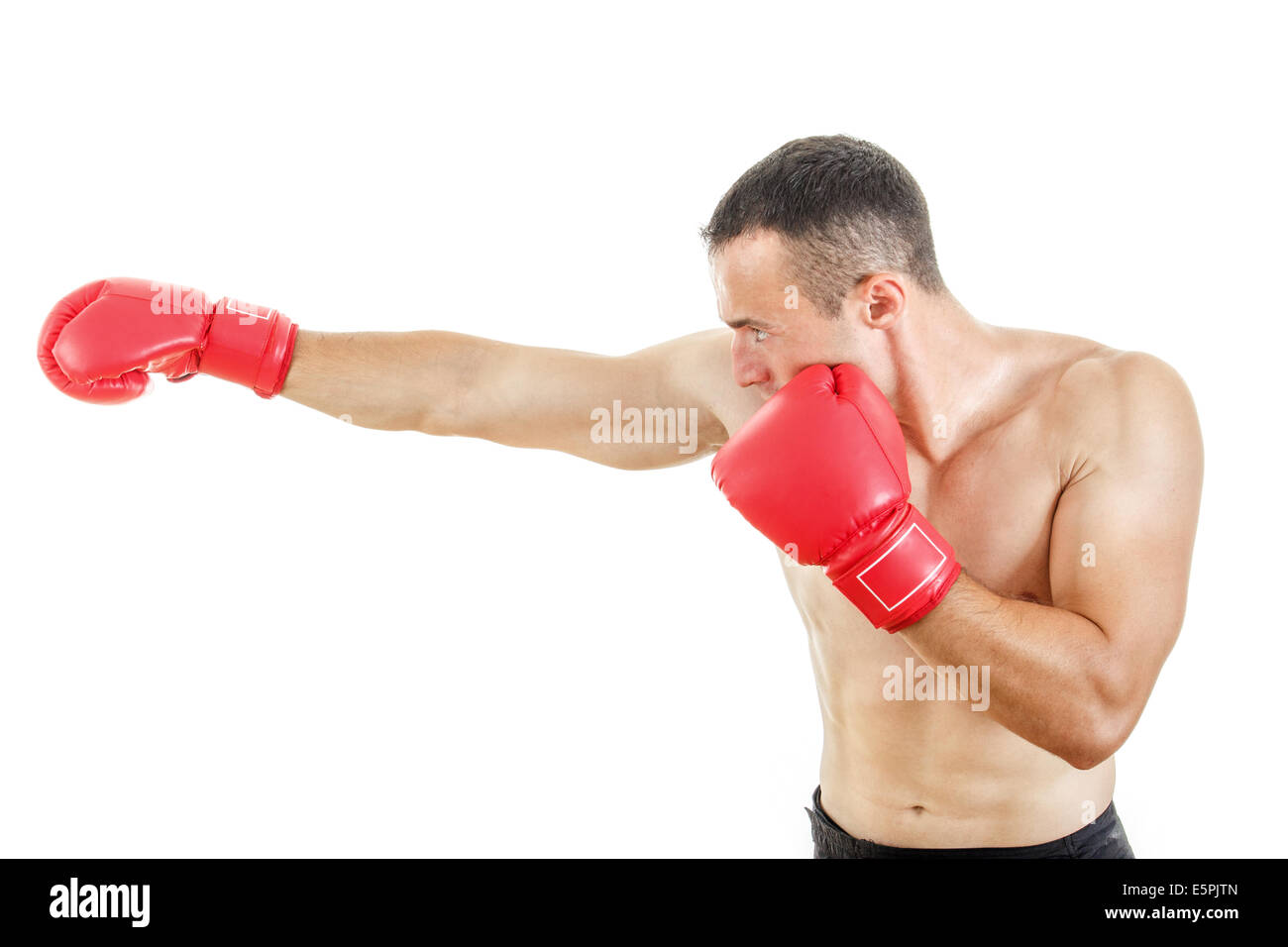 side view of muscular man wearing red boxing gloves and punching on
