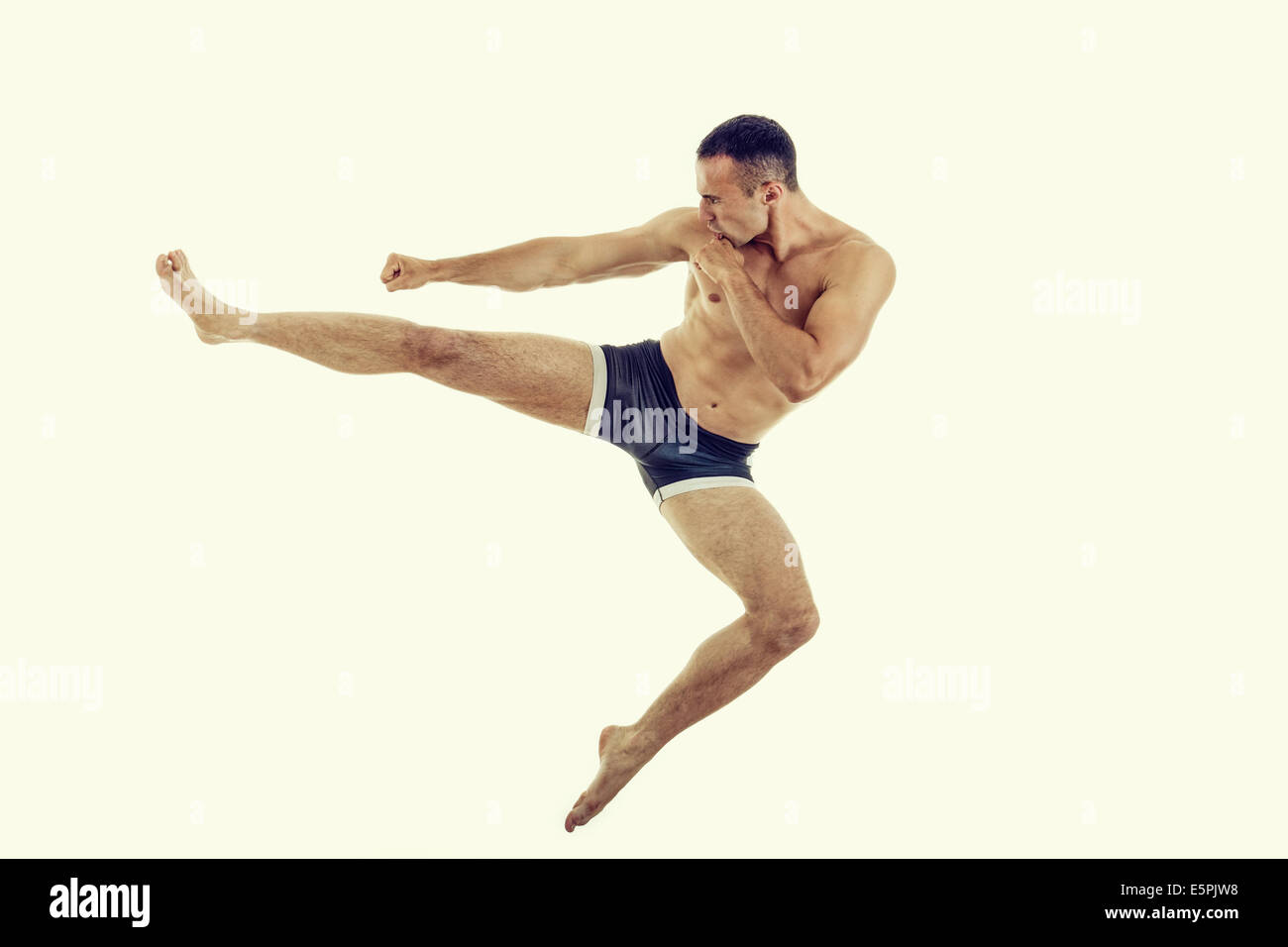 Boxercise Kick Young muscular boxer fighter doing exercise with a perfect kick in the ...