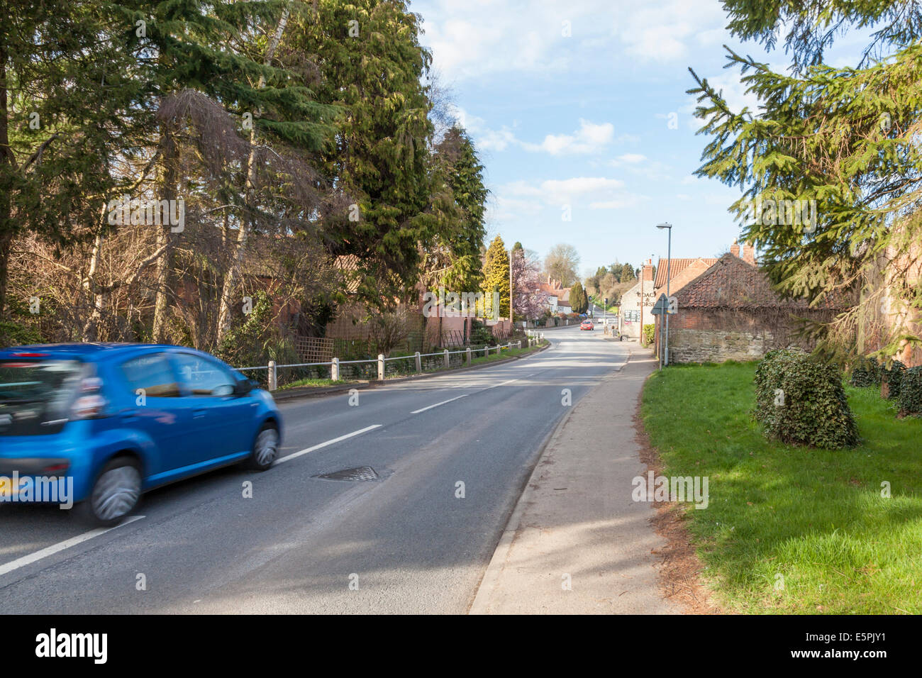 A fast car speeding through a rural village, Thurgaton, Nottinghamshire, England, UK Stock Photo