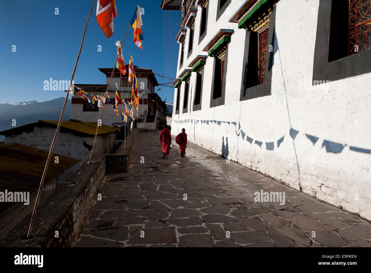 Buddhist monks walking in the early morning sunshine on the walls of Tawang Buddhist monastery, Arunachal Pradesh, India Stock Photo