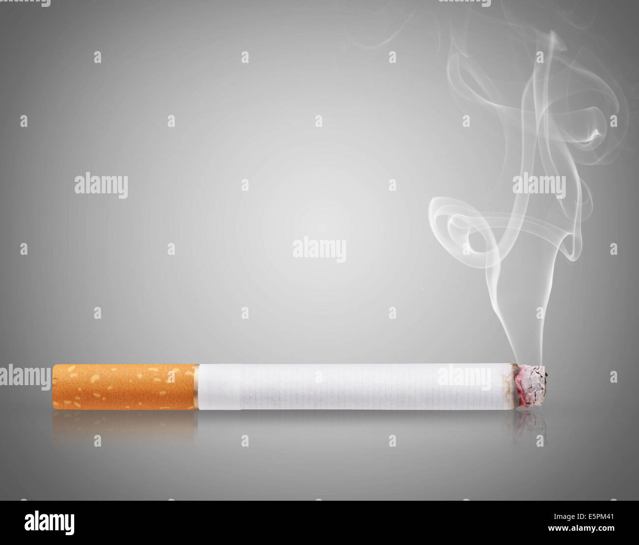 Cigarette burns on gray background Stock Photo